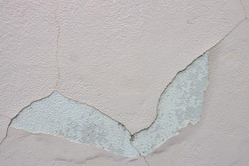 Stock Image: White exterior wall texture with cracked plastering