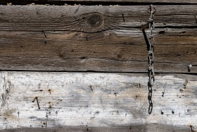 Stock Image: wood wall texture with rusty nails and a chain