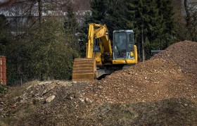 Stock Image: yellow excavator and a heap of earth