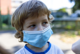 Stock Image: young boy with a mask - protection against covid-19 coronavirus