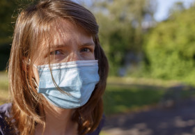 Stock Image: young woman with a mask - protection against covid-19 coronavirus