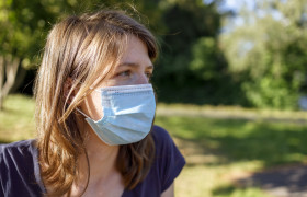 Stock Image: young woman with a mask - protection against covid-19 coronavirus